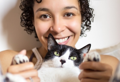 Young lady holding black and white cat